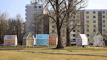 Die Häuser mit bunt bedruckten Fassaden und Dächern.